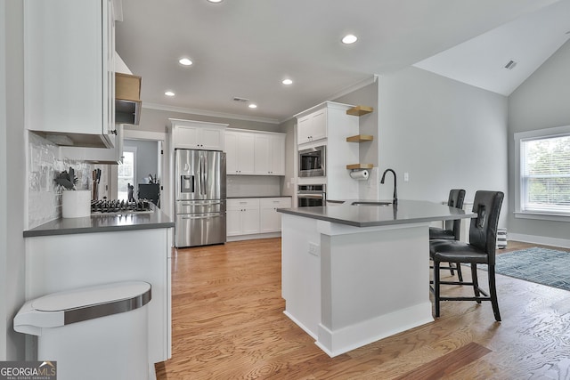 kitchen with white cabinets, stainless steel appliances, kitchen peninsula, and sink