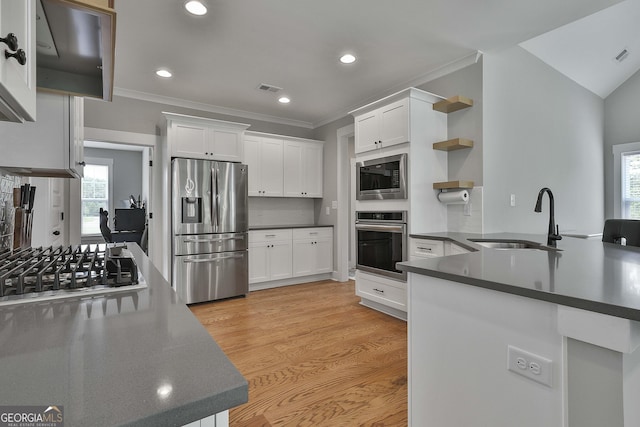 kitchen with sink, light wood-type flooring, white cabinetry, kitchen peninsula, and stainless steel appliances