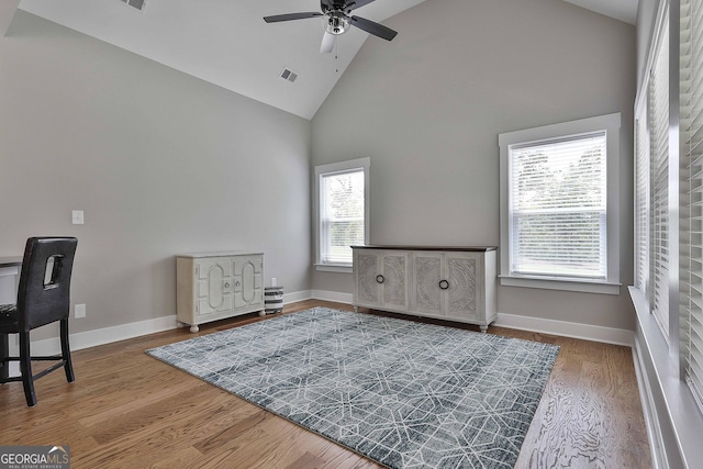 interior space with ceiling fan, high vaulted ceiling, and hardwood / wood-style flooring