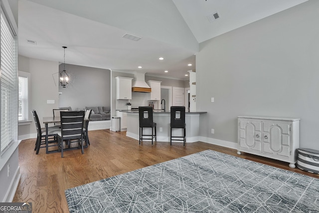 interior space featuring dark hardwood / wood-style floors, an inviting chandelier, sink, and vaulted ceiling