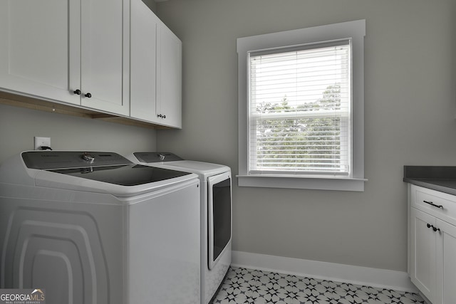 clothes washing area with washer and dryer and cabinets