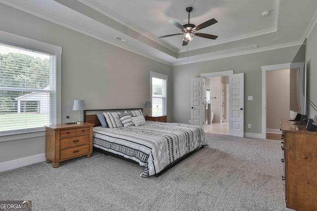 bedroom featuring multiple windows, carpet floors, a tray ceiling, and ceiling fan