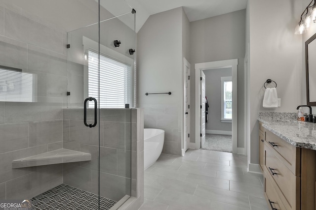 bathroom featuring lofted ceiling, vanity, separate shower and tub, and a healthy amount of sunlight