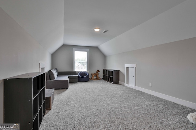 sitting room with carpet and vaulted ceiling