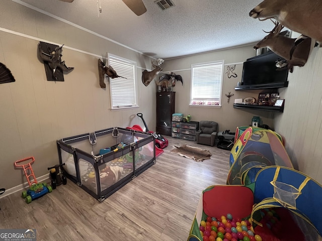 game room featuring a textured ceiling, hardwood / wood-style flooring, and ceiling fan