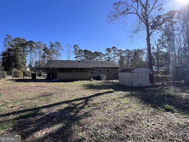 rear view of house featuring a storage unit