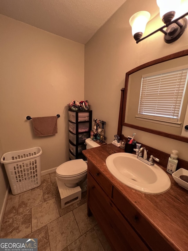 bathroom with vanity, a textured ceiling, and toilet