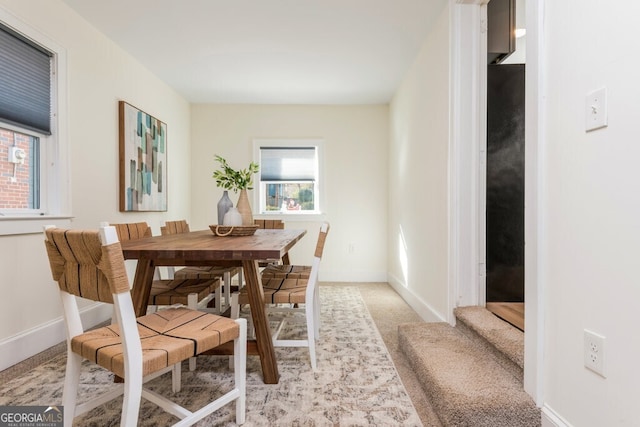 dining area featuring light carpet