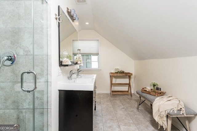 bathroom with tile patterned floors, vanity, a shower with shower door, and vaulted ceiling