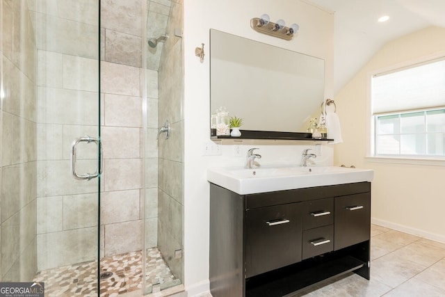 bathroom with tile patterned flooring, vanity, walk in shower, and vaulted ceiling