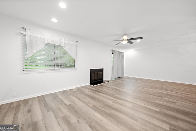 unfurnished living room featuring ceiling fan and light hardwood / wood-style flooring