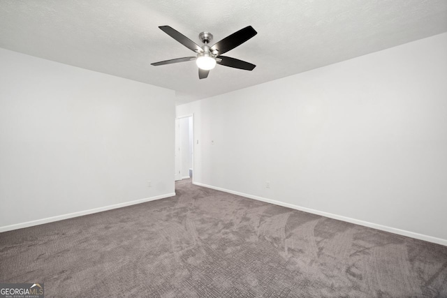 spare room with ceiling fan, a textured ceiling, and dark colored carpet