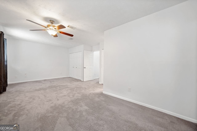 carpeted spare room with a textured ceiling and ceiling fan