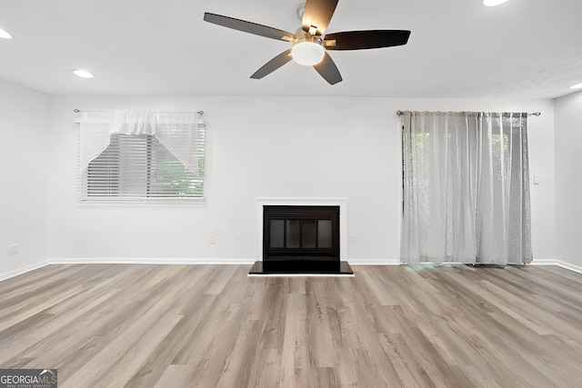 unfurnished living room with ceiling fan and light hardwood / wood-style flooring