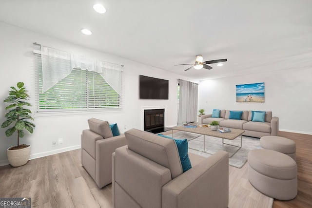 living room featuring light hardwood / wood-style floors and ceiling fan