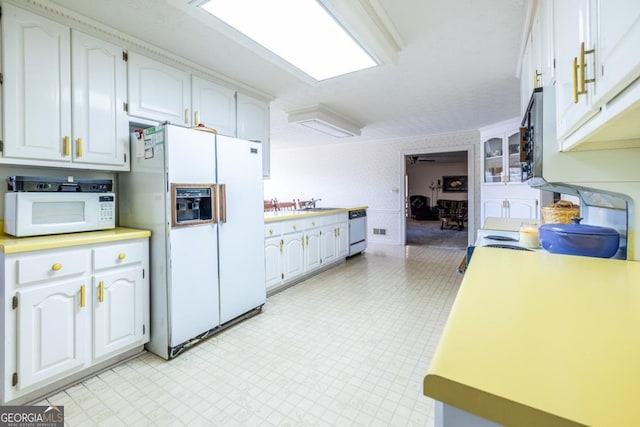 kitchen featuring white cabinets and white appliances