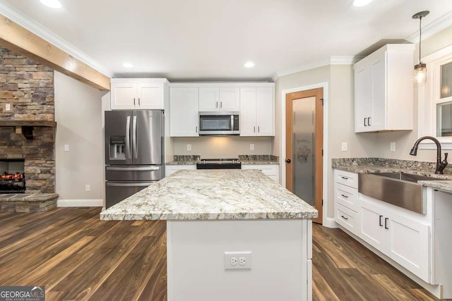 kitchen featuring light stone countertops, white cabinetry, pendant lighting, and appliances with stainless steel finishes