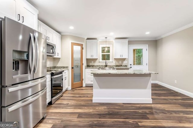 kitchen featuring pendant lighting, white cabinets, a kitchen island, light stone counters, and stainless steel appliances