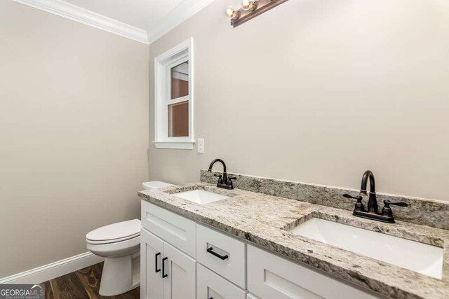 bathroom with hardwood / wood-style floors, vanity, toilet, and ornamental molding