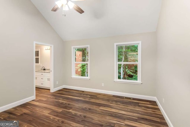 unfurnished bedroom featuring multiple windows, connected bathroom, ceiling fan, and sink