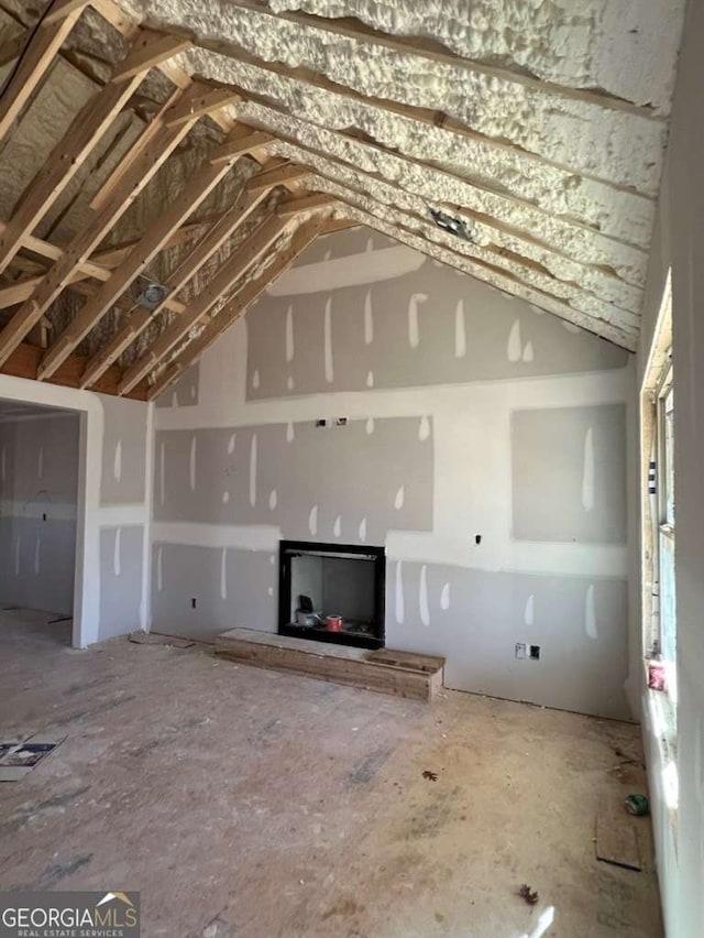 unfurnished living room featuring lofted ceiling