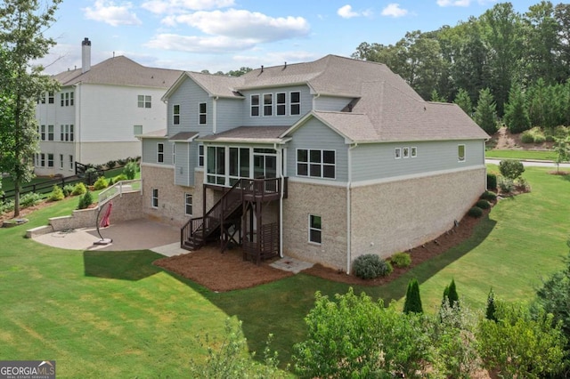 back of house with a sunroom, a patio area, and a lawn