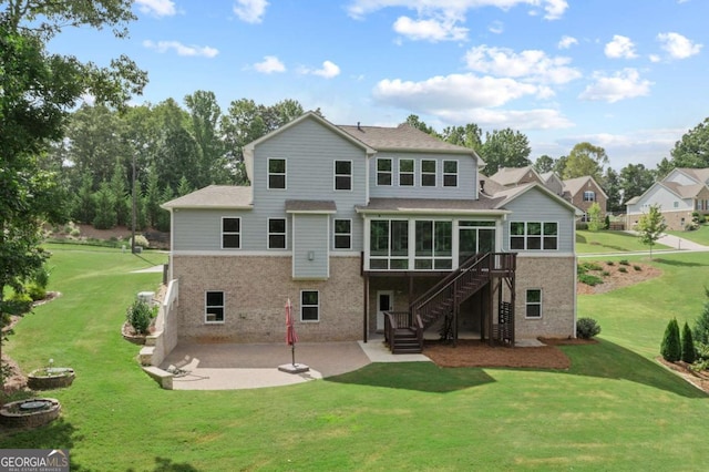 rear view of property with a yard, a deck, and a patio area