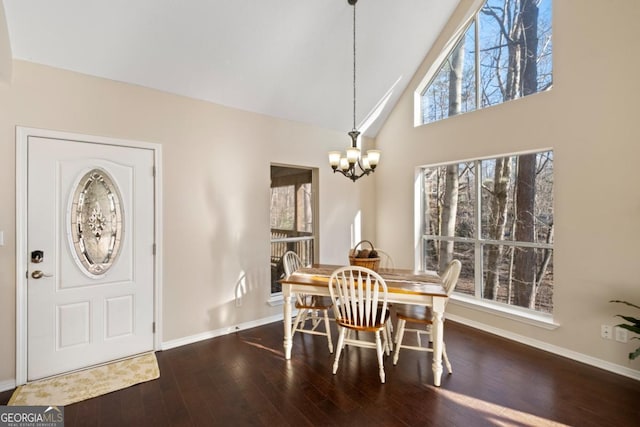 dining area featuring dark wood-type flooring, high vaulted ceiling, and a chandelier