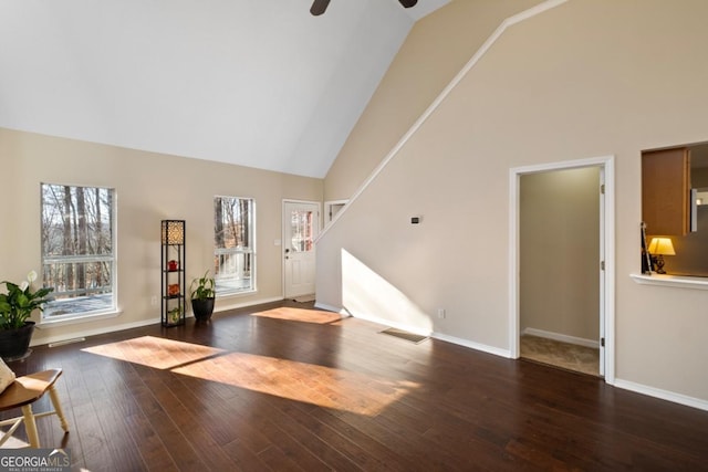 entrance foyer with plenty of natural light, ceiling fan, dark wood-type flooring, and high vaulted ceiling