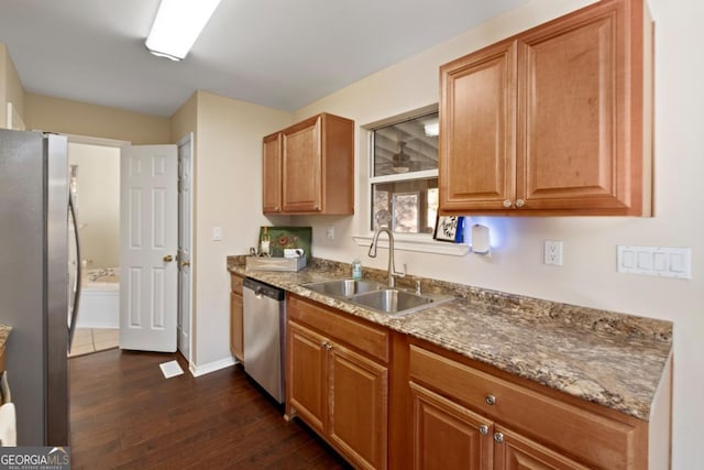 kitchen with sink, dark wood-type flooring, stone countertops, and appliances with stainless steel finishes