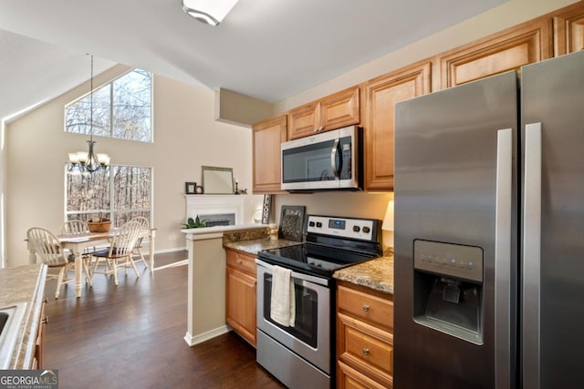 kitchen with light stone countertops, hanging light fixtures, dark hardwood / wood-style floors, a chandelier, and appliances with stainless steel finishes