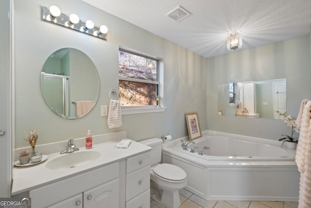 bathroom with tile patterned floors, vanity, a textured ceiling, toilet, and a bathing tub