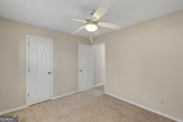 unfurnished bedroom with ceiling fan and light carpet