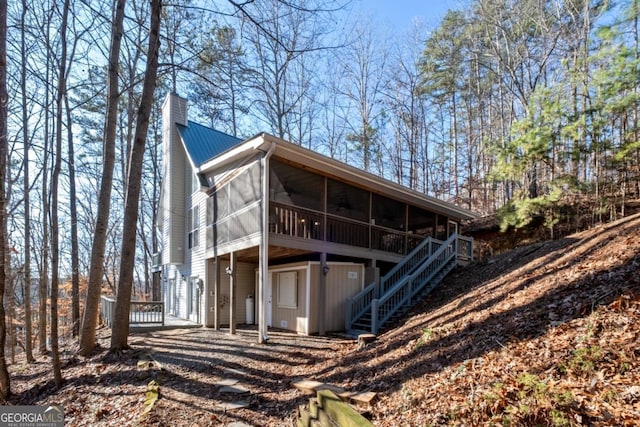 rear view of property featuring a sunroom