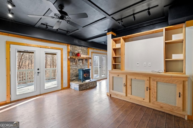 unfurnished living room with hardwood / wood-style flooring, ceiling fan, track lighting, and french doors