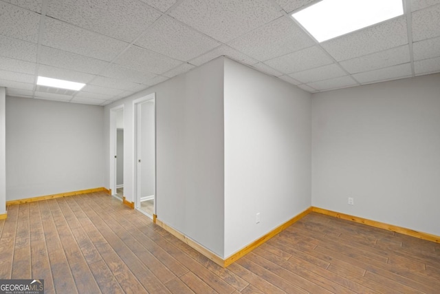 basement with hardwood / wood-style floors and a drop ceiling