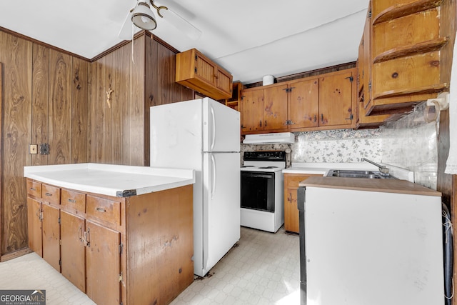 kitchen featuring ceiling fan, sink, tasteful backsplash, wood walls, and white appliances