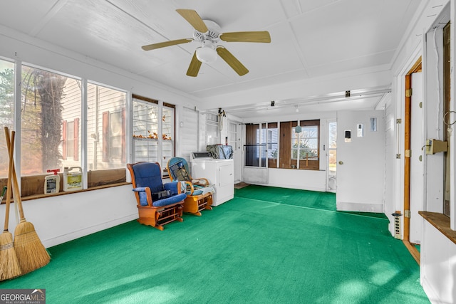 living area with separate washer and dryer, ceiling fan, and dark carpet