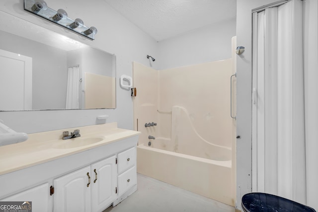 bathroom featuring vanity, a textured ceiling, and bathtub / shower combination