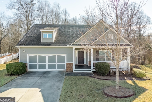 view of front of house with a porch, a garage, and a front yard