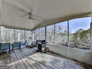 unfurnished sunroom featuring ceiling fan