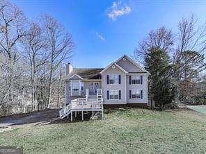 rear view of house with a yard and a wooden deck