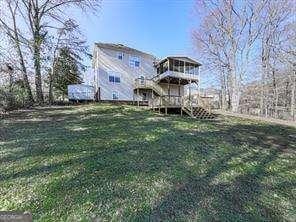 back of property featuring a deck and a yard