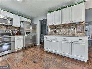 kitchen featuring white cabinets, appliances with stainless steel finishes, and tasteful backsplash