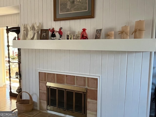 details with hardwood / wood-style floors and a brick fireplace