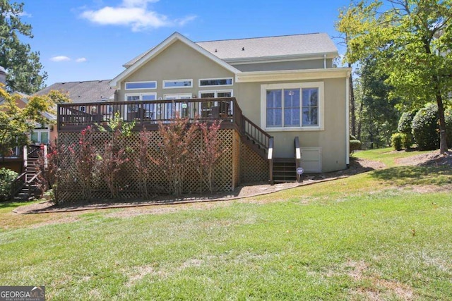 rear view of house featuring a lawn and a wooden deck