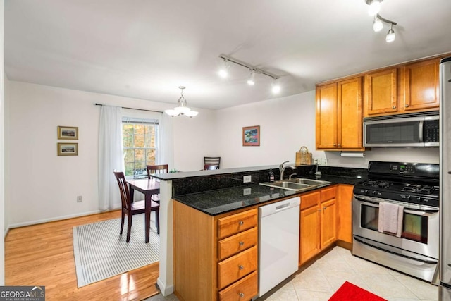 kitchen featuring sink, decorative light fixtures, a notable chandelier, kitchen peninsula, and stainless steel appliances