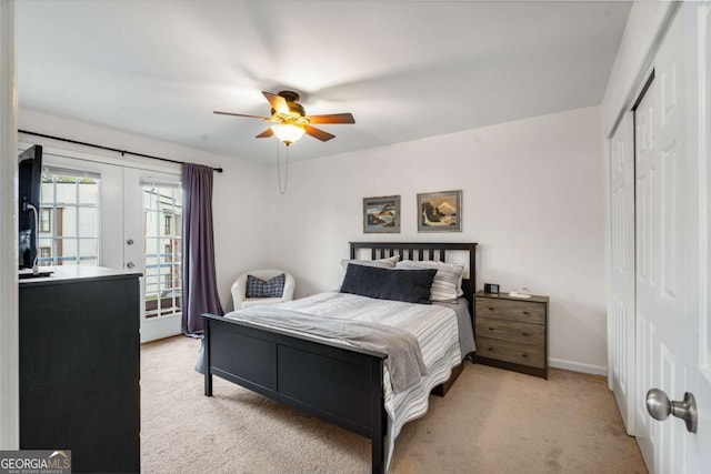 carpeted bedroom with french doors, a closet, and ceiling fan