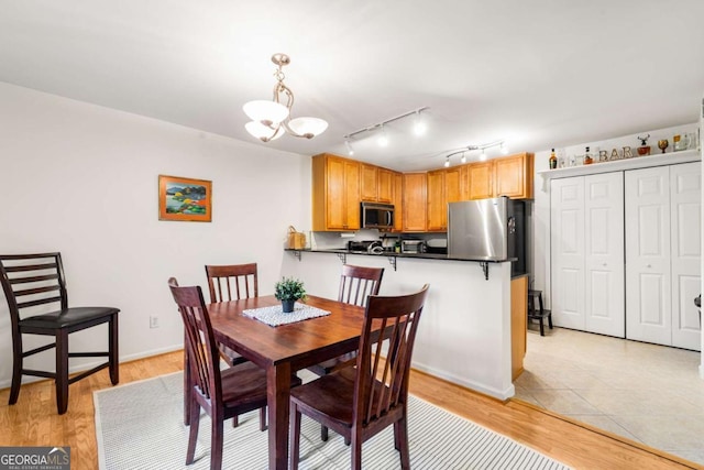 dining room featuring light hardwood / wood-style flooring and an inviting chandelier