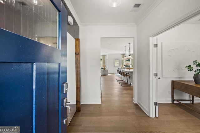 corridor featuring hardwood / wood-style floors and ornamental molding